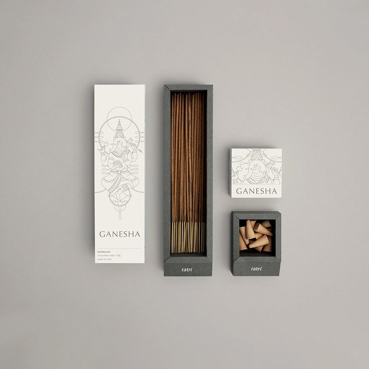 an open box of incense sticks next to two boxes of matches on a gray surface