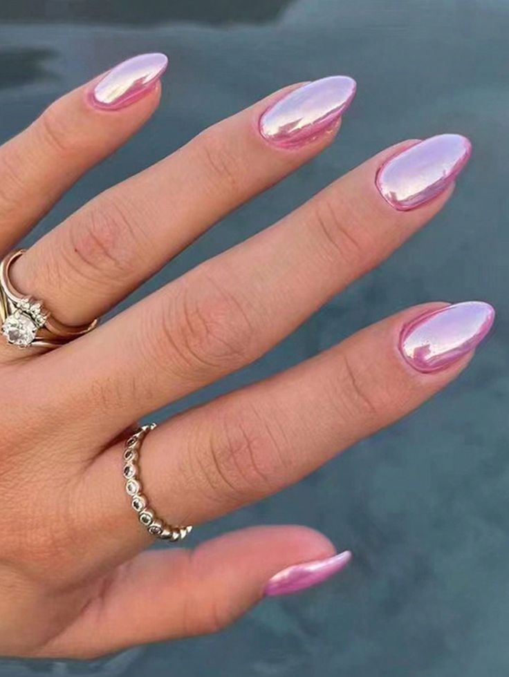 a woman's hand with pink and white manies on it, holding a ring