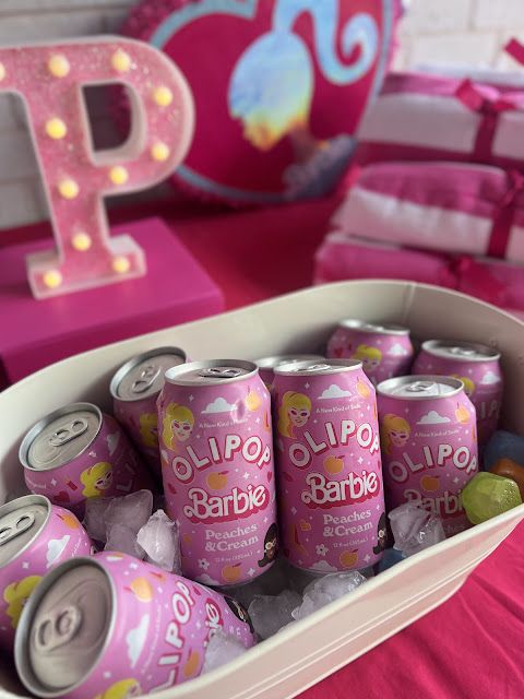 the pink table is filled with cans of drink