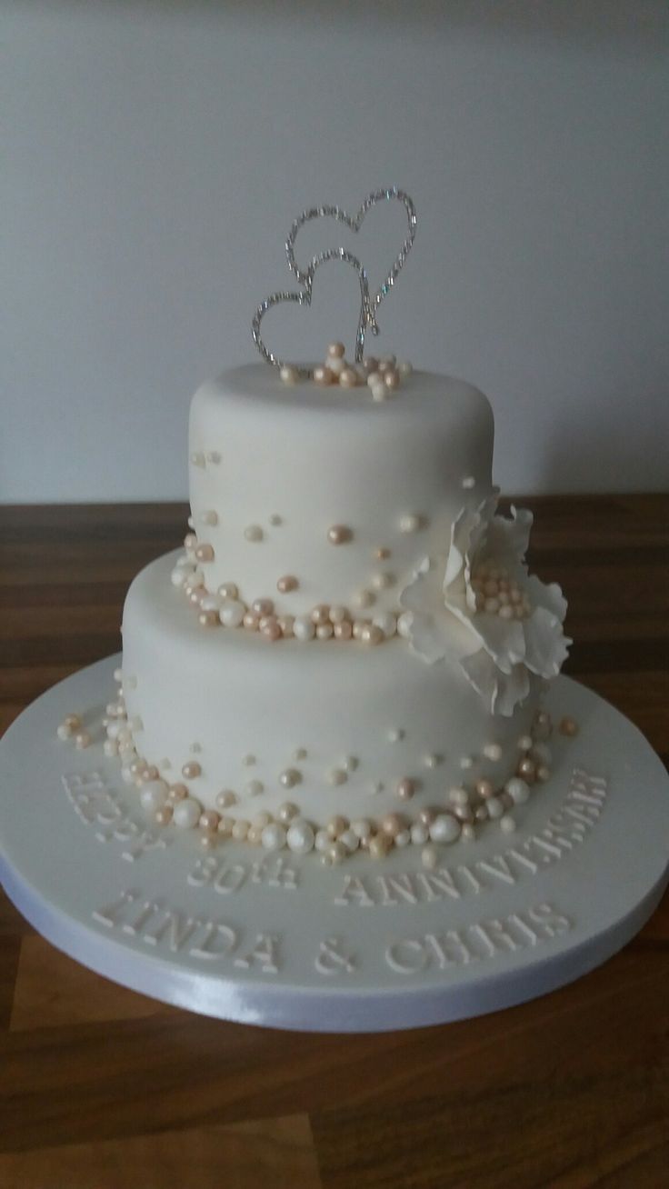 a wedding cake with pearls and a tiara on top