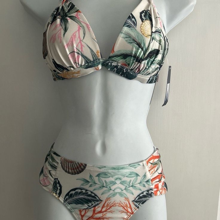 This Ruched Bikini Brief And Pleated Bikini Top From Rachel Roy Features A Floral Design, Ruched Side Detail, And Full Lining With Classic Coverage Bottom. Coral Reef Print This Halter Bikini Top From Rachel Roy Features A Solid Color Design, Removable Soft Pads, Full Lining, Deep V-Neck, Tie-Back Closure, And Halter Neck. Fabrication 82% Nylon, 18% Spandex. Internal Shelf Bra Molded Cups Hand Wash Lay Flat To Dry Nylon Spandex Coral Reef Size Medium Questions? Leave A Comment Below! Tropical Underwire Tankini For Beach Season, Summer Tropical Underwire Tankini, Tropical Underwire Tankini For Summer, Tropical Underwire Tankini For Vacation, Fitted Tropical Tankini For Vacation, Fitted Tropical Tankini For Beach Season, Fitted Halter Neck Tropical Tankini, Fitted Tropical Print Halter Neck Tankini, Fitted Tropical Tankini For Sunbathing