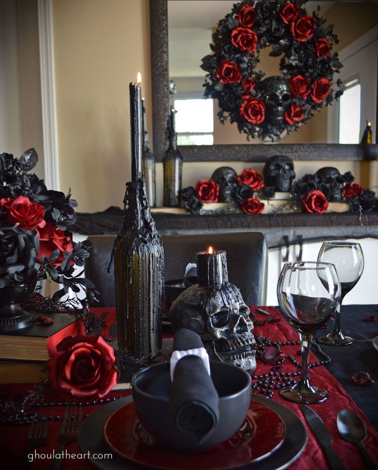 a dining room table decorated with red roses and black candlesticks for halloween decorations