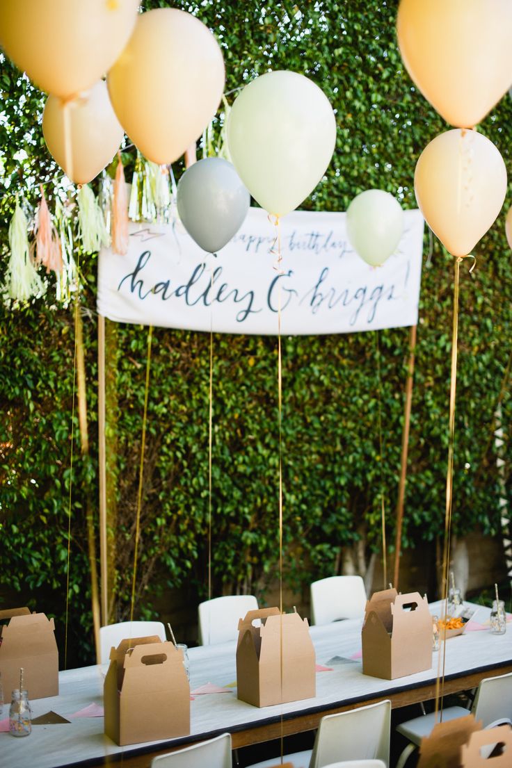 a table set up for a party with balloons