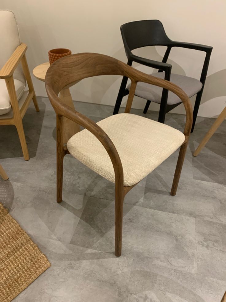 two chairs sitting next to each other on top of a carpeted floor in front of a white wall