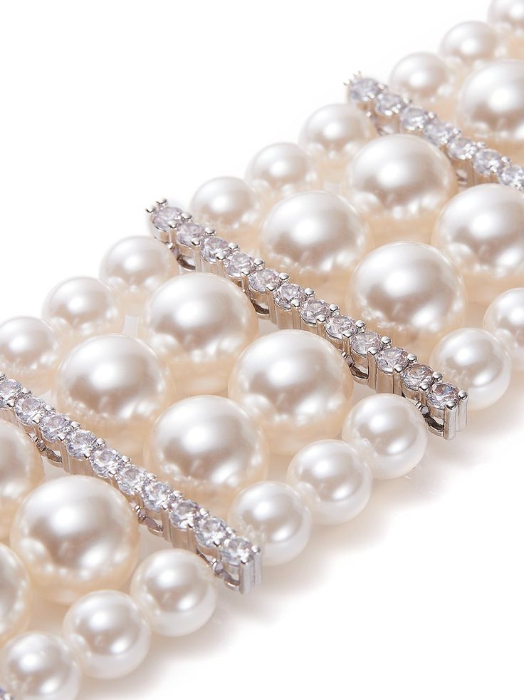 Introducing the Suzette Pearl Bracelet, a dazzling statement piece that exudes timeless elegance and sophistication. Crafted with exquisite craftsmanship, this bracelet features four layers of lustrous pearls and shimmering crystals, creating a mesmerizing cascade of beauty.  Each pearl glows with a luminous allure, while the crystals add a touch of sparkle and glamour to elevate any ensemble. The layered design of the bracelet offers depth and dimension, making it a striking focal point for any Pearl Bracelets For Party, Pearl Embellished Party Bracelet, Elegant Evening Bracelets With Sparkling Stones, Formal Pearl Embellished Bracelet Jewelry, Formal Pearl Embellished Bracelet, Luxury Pearl Bracelet For Evening, Elegant Pearl Charm Bracelet For Parties, Elegant Pearl Bracelet With Charm For Parties, Elegant Pearl Drop Bracelet For Party