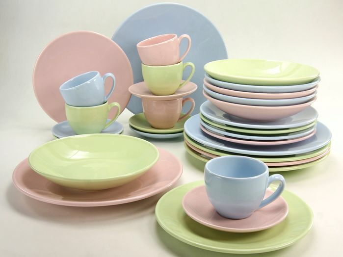 a table topped with lots of different colored plates and cups on top of each other