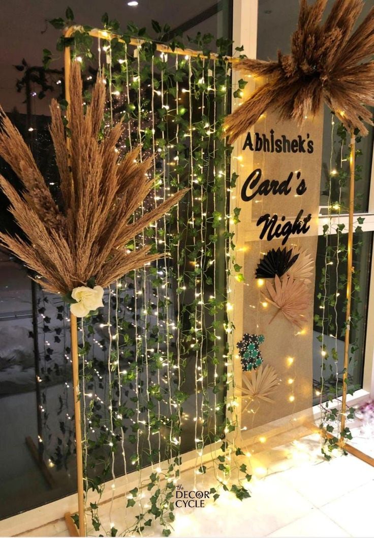 two tall grass plants are on display in front of a sign that says abishke's card's night