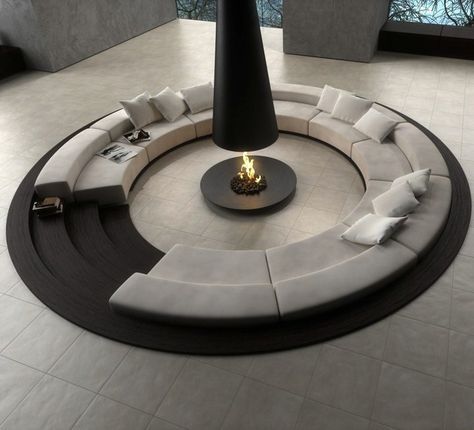 a circular couch sitting in the middle of a living room next to a fire place