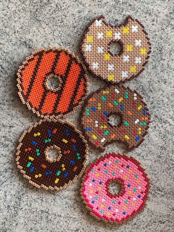 four donuts with different colors and designs are on the ground next to each other