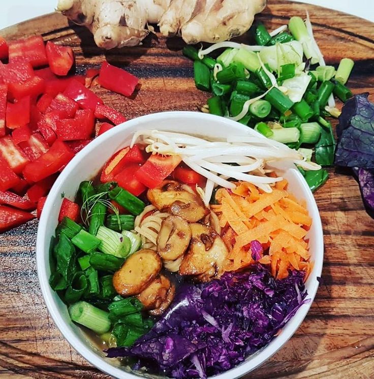 the bowl is full of different vegetables and meats, including carrots, broccoli, red cabbage