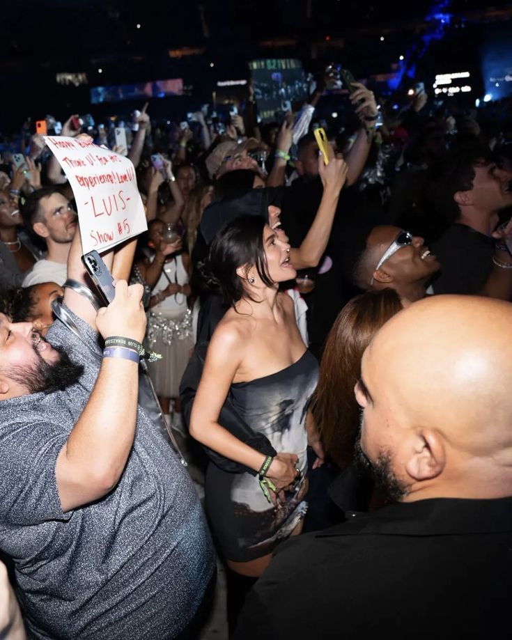 a group of people standing around each other at a concert