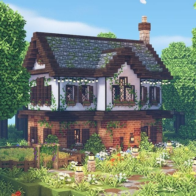 a house in the middle of some trees and bushes with lots of flowers around it