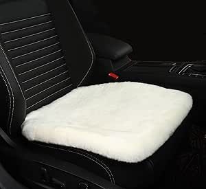 the interior of a car with black leather and white sheepskin seat covers on it