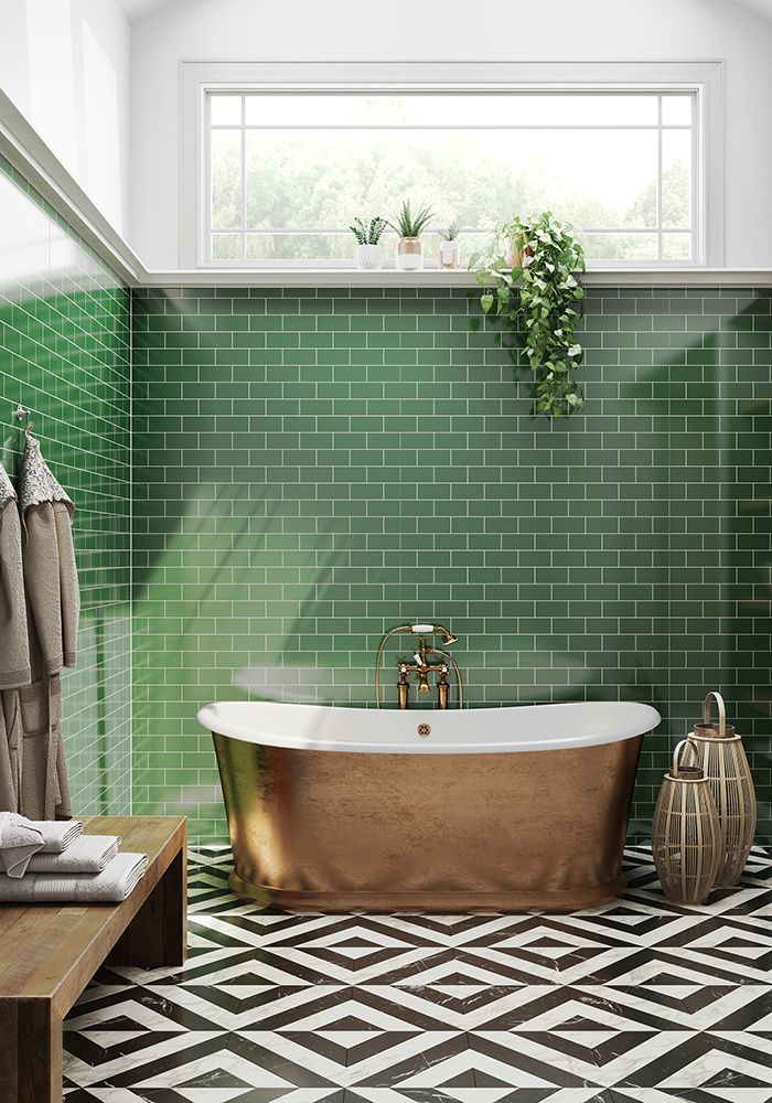 a bath tub sitting next to a window in a green tiled bathroom with black and white flooring