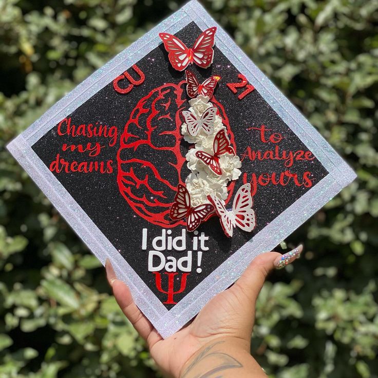 someone is holding up a graduation cap with butterflies on it that says i did it dad