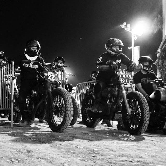 black and white photograph of motorcyclists at night