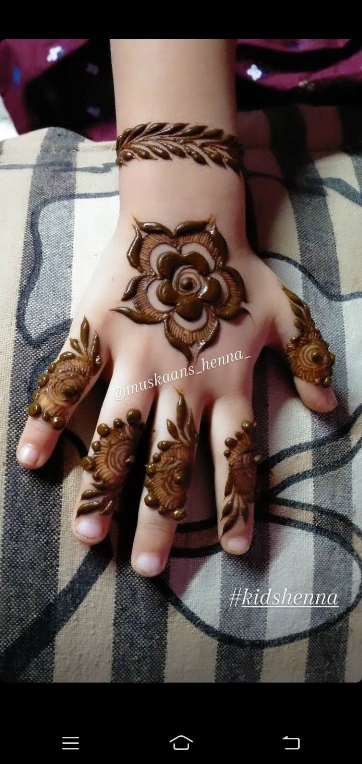 a woman's hand with henna tattoos on it