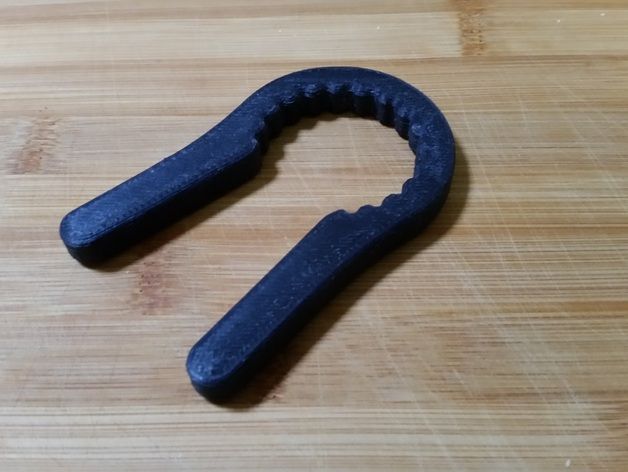 a black object sitting on top of a wooden table next to a pair of scissors