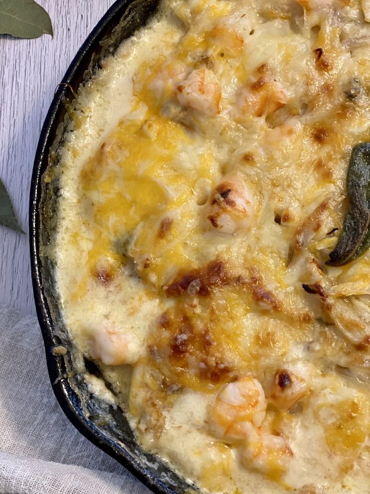 a casserole dish with shrimp and cheese