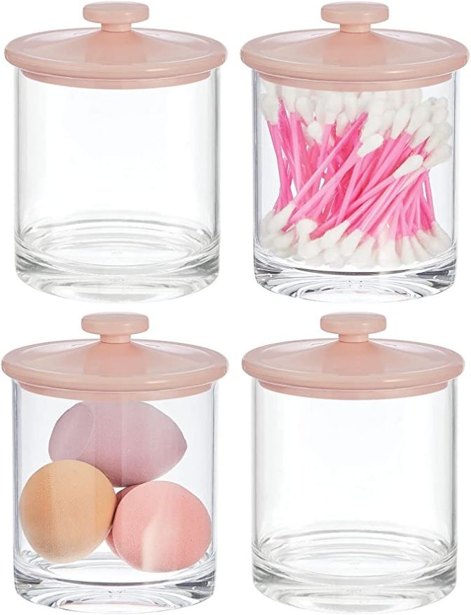 four glass containers with pink lids filled with eggs