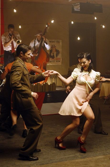 a man and woman are dancing together in the middle of a dance floor with other people