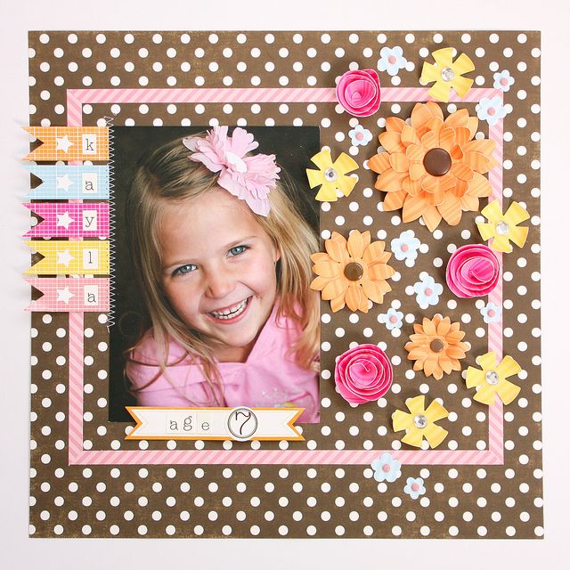 a child's photo frame with flowers and ribbons on the front, along with a polka dot background