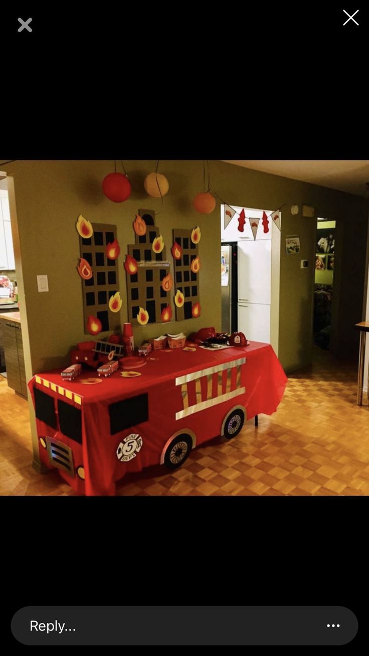 a firetruck themed birthday party with red table cloths and paper lanterns hanging from the ceiling