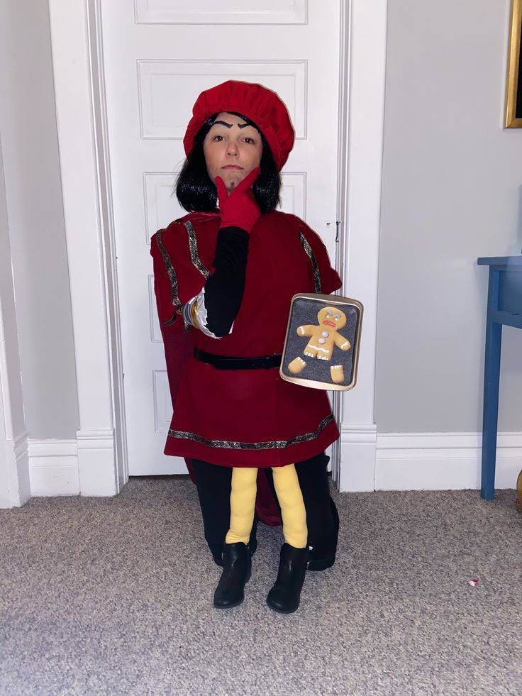 a woman in a red coat and hat holding a cookie box with a teddy bear on it