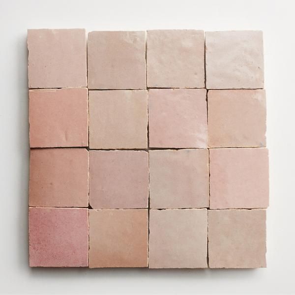 several square tiles arranged on top of each other in pink and beige colors, with one block missing the middle