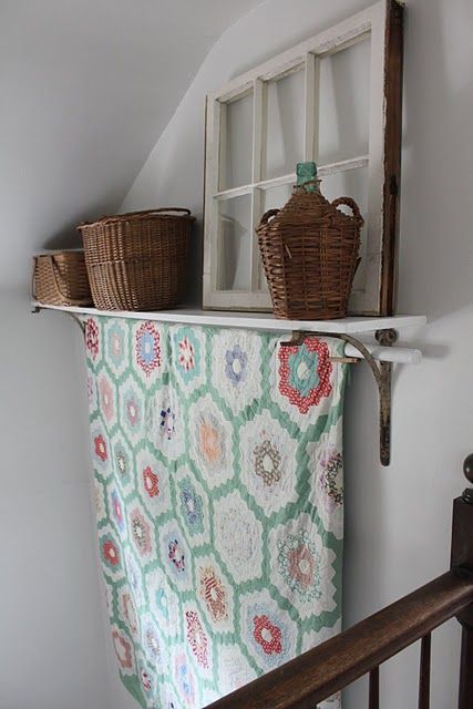 an old window is hung on the wall above a towel rack with baskets in it