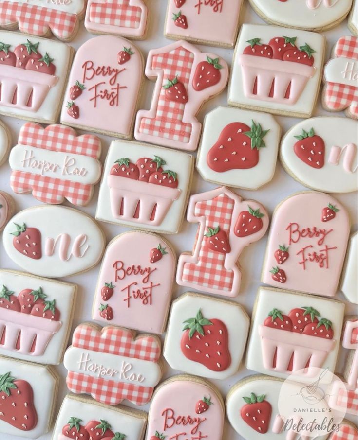 decorated cookies are arranged in the shape of letters and numbers with strawberries on them