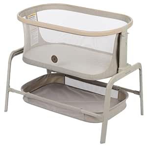 a baby bassinet that is sitting on top of a white surface with a beige frame