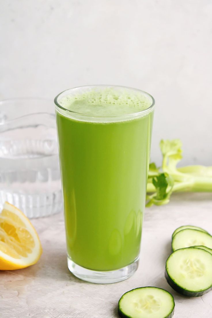 a green drink with cucumbers next to it