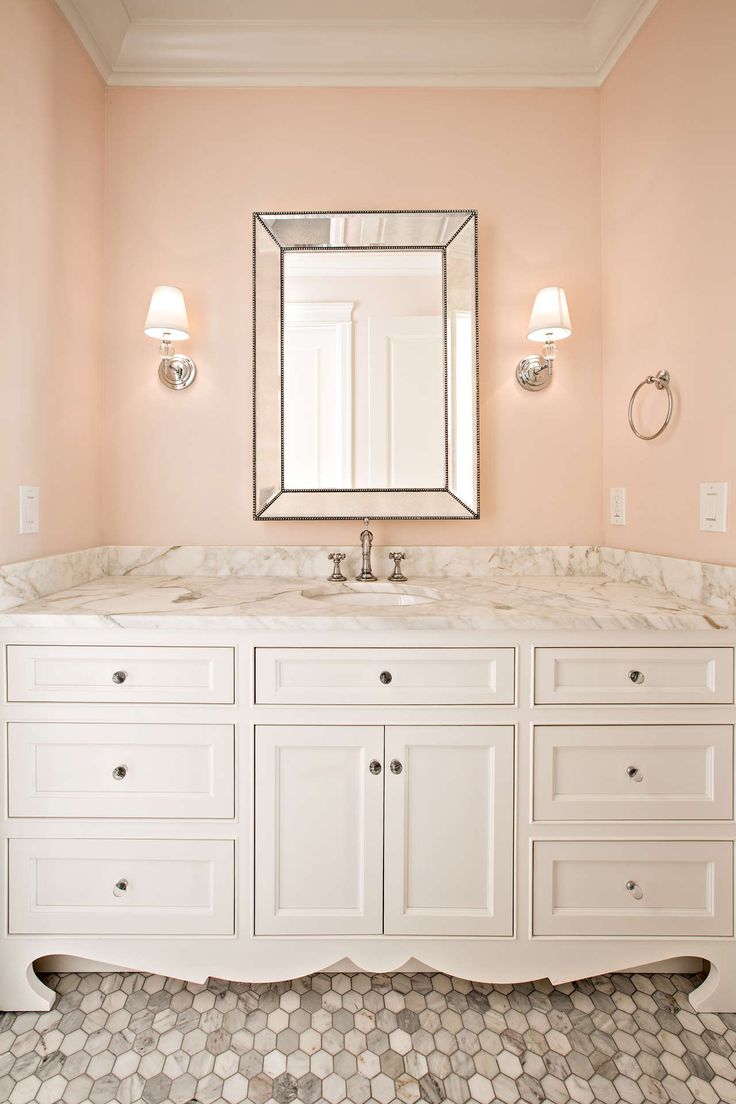 a bathroom with a large mirror and two lights on the wall next to it's double vanity