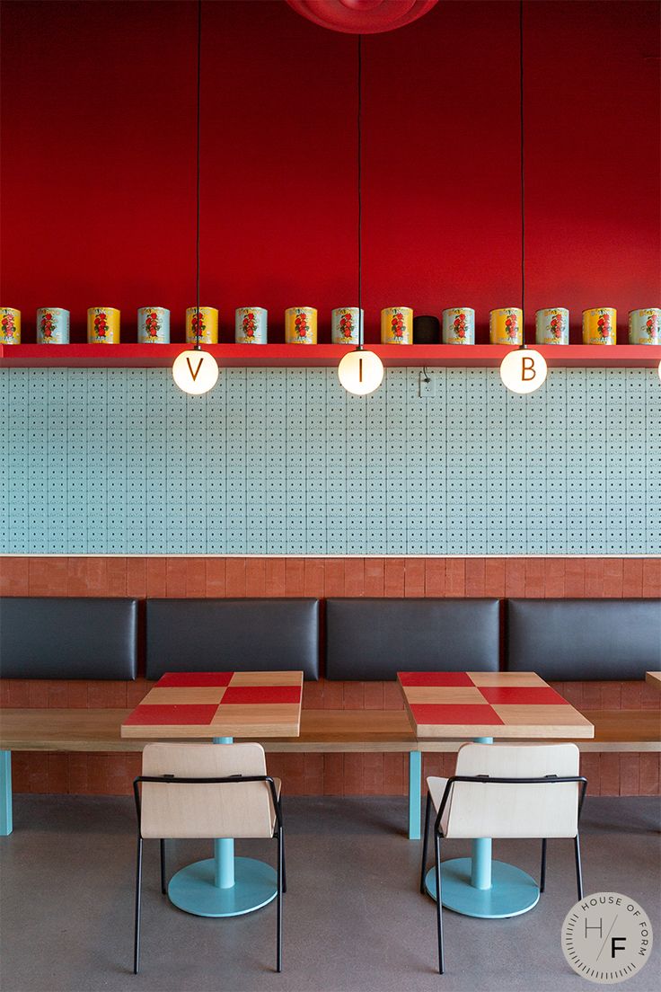 a restaurant with red walls and wooden tables