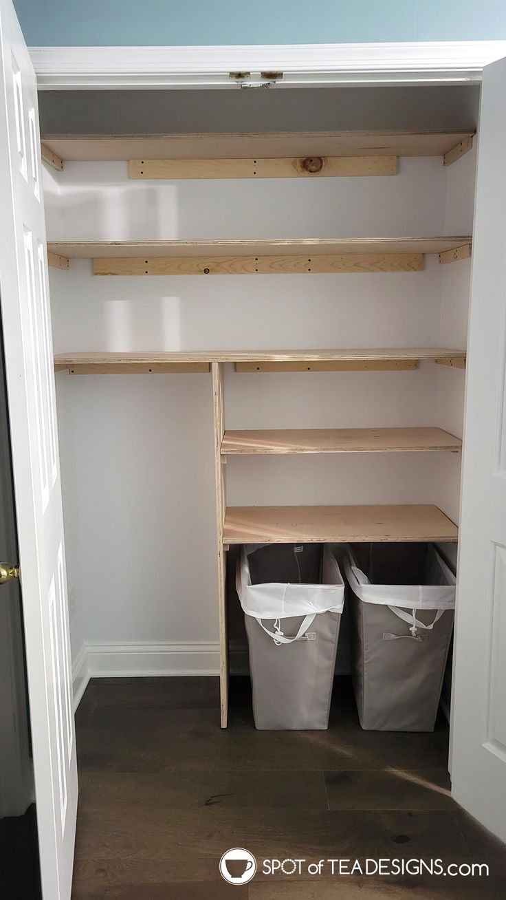 an empty closet with two bins and shelves