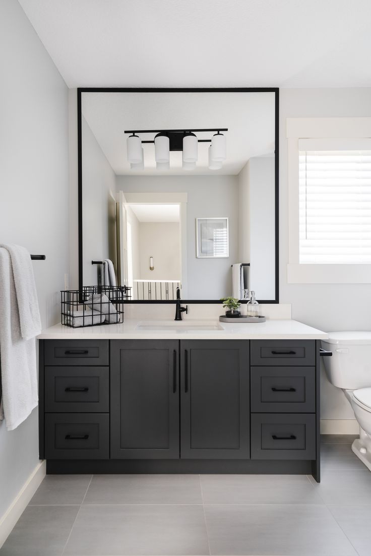 a bathroom with a sink, mirror and toilet in it's centerpieces