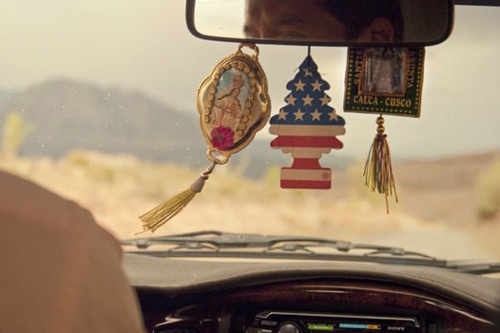 the interior of a car with an american flag decoration hanging from it's dash board