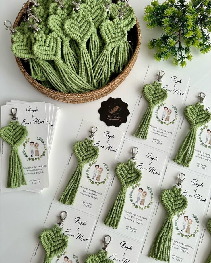 green crochet keychains are displayed on a table with cards and tags