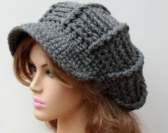 a mannequin head wearing a gray crochet newsboy hat on top of a wig