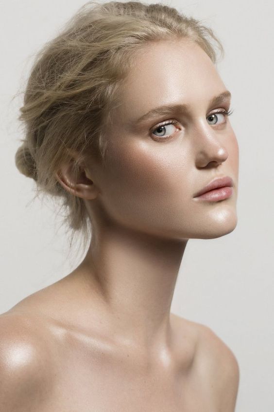 a woman with blonde hair and blue eyes is posing for the camera, she has her face slightly turned to the side