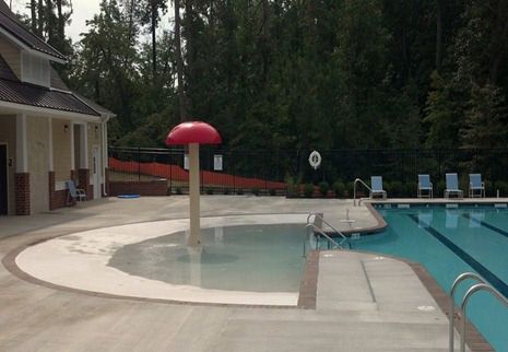 an empty swimming pool with lounge chairs around it