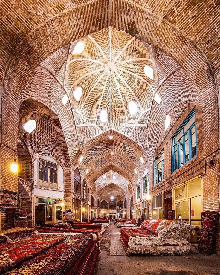 the inside of an old building with many couches and rugs on the floor