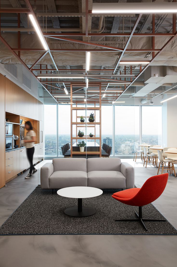 a living room filled with furniture next to a tall window covered in lots of windows