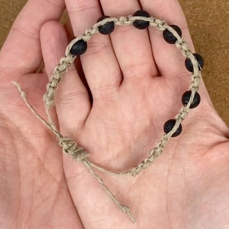 a hand holding a string with beads on it in the palm of someone's hand