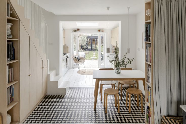 a dining room table and chairs in front of a bookshelf