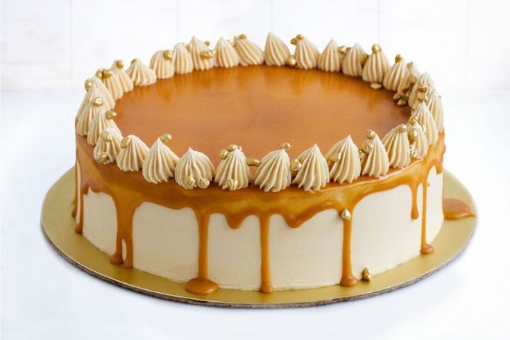 a cake with white icing and caramel drizzles on it's top