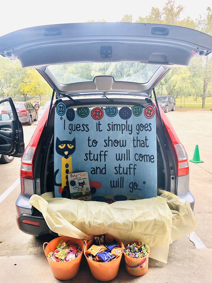 the back end of a car with an open trunk filled with buckets and cups