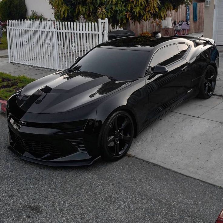 a black sports car parked in front of a house