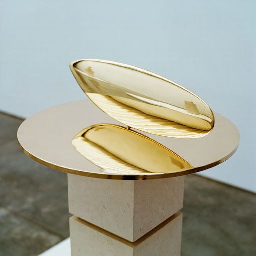 a gold plate sitting on top of a white pedestal